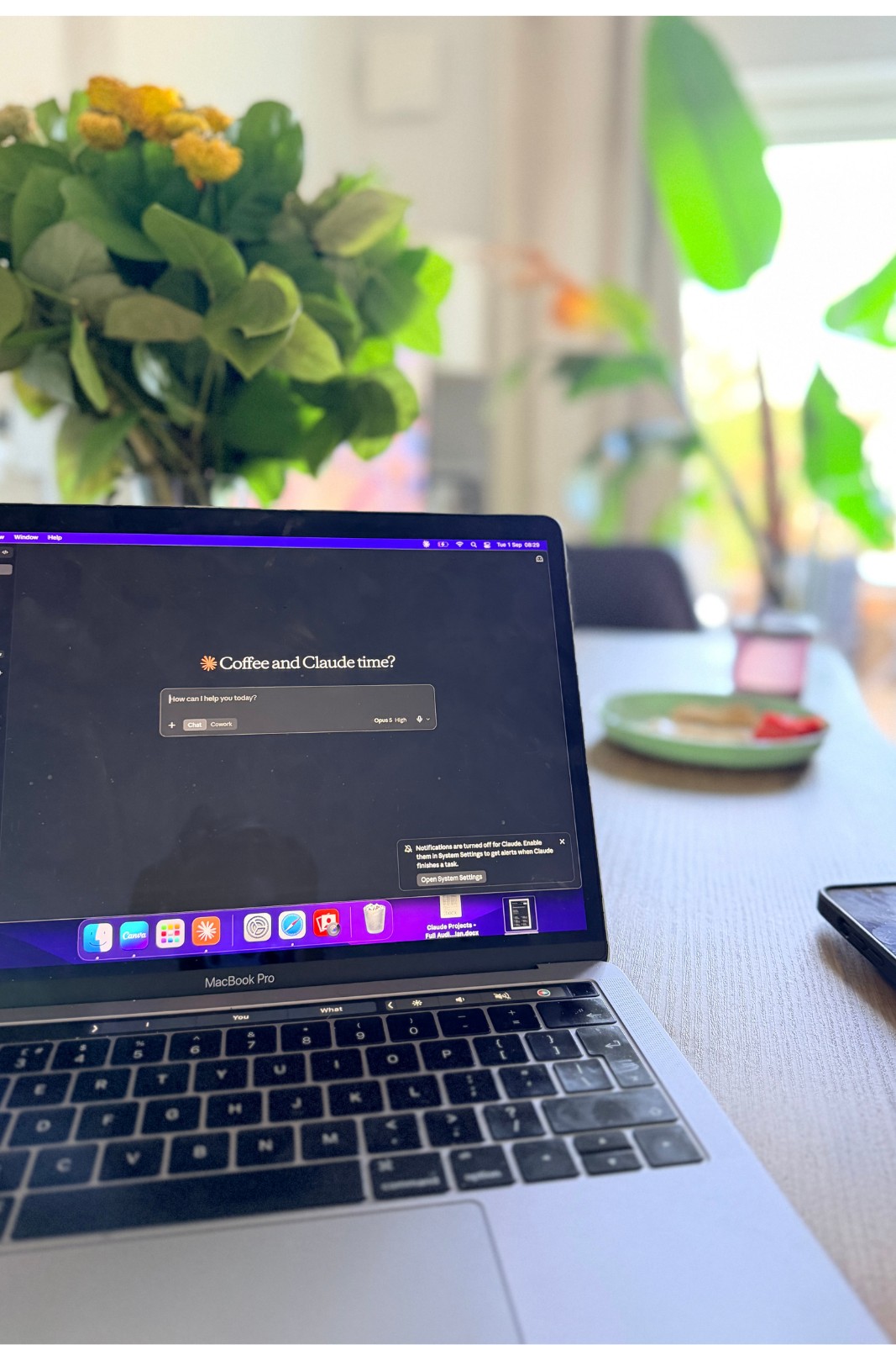 A laptop open on a kitchen table with an AI assistant on screen.